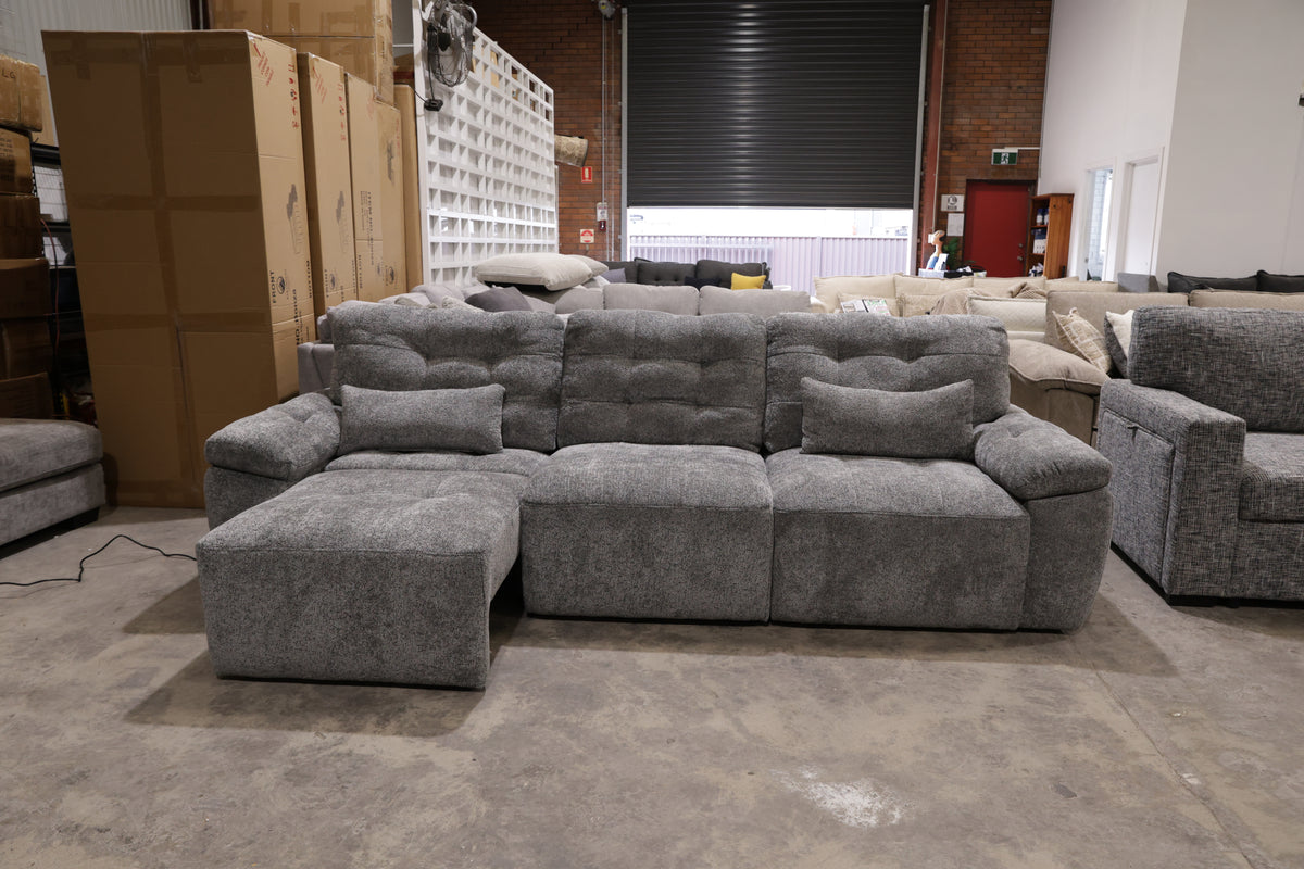 Dark grey 3 seater electric sliding lounge with plush tufted backrests and wide padded armrests.