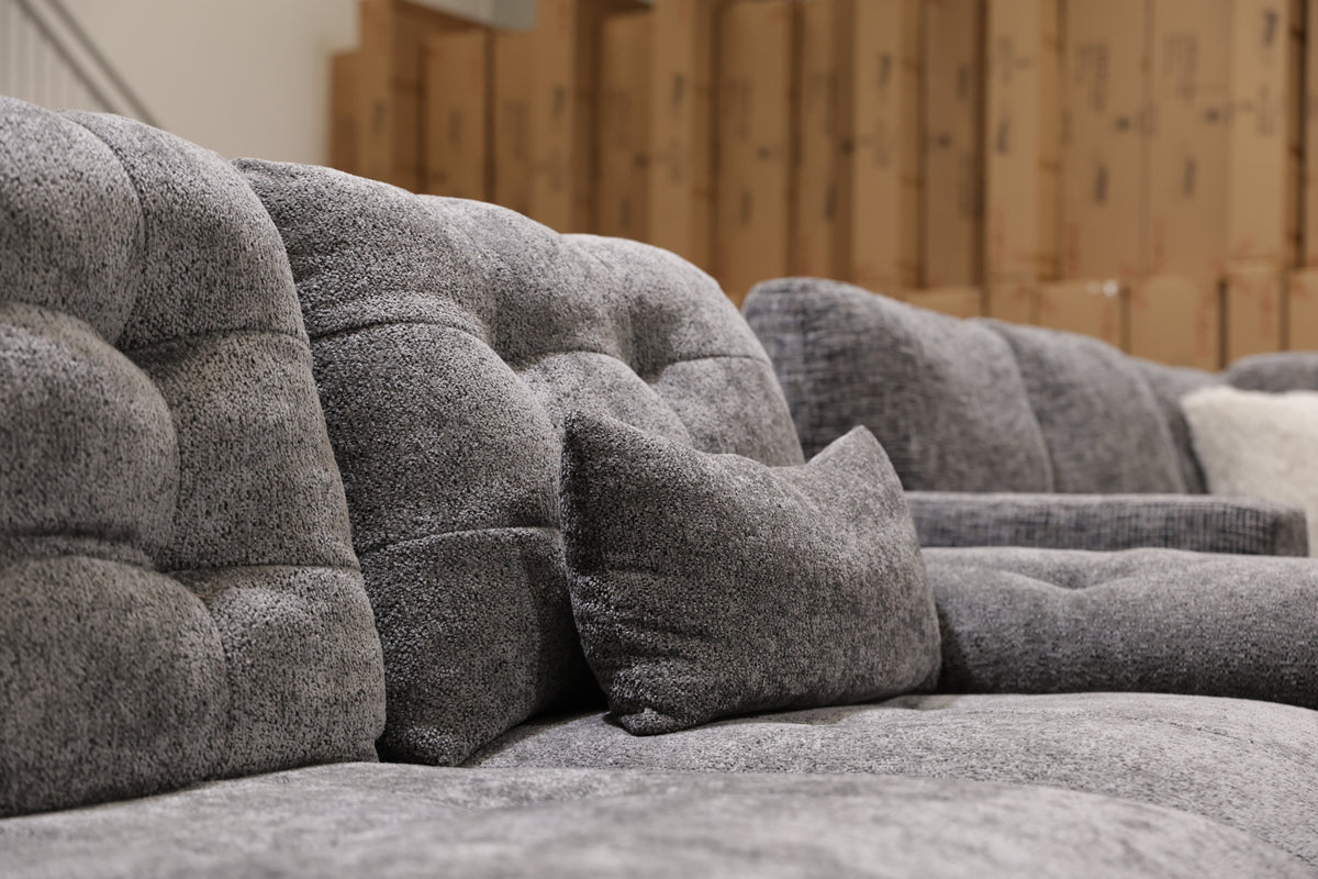 Fully extended 3 seater electric lounge in textured dark grey fabric with matching lumbar cushions